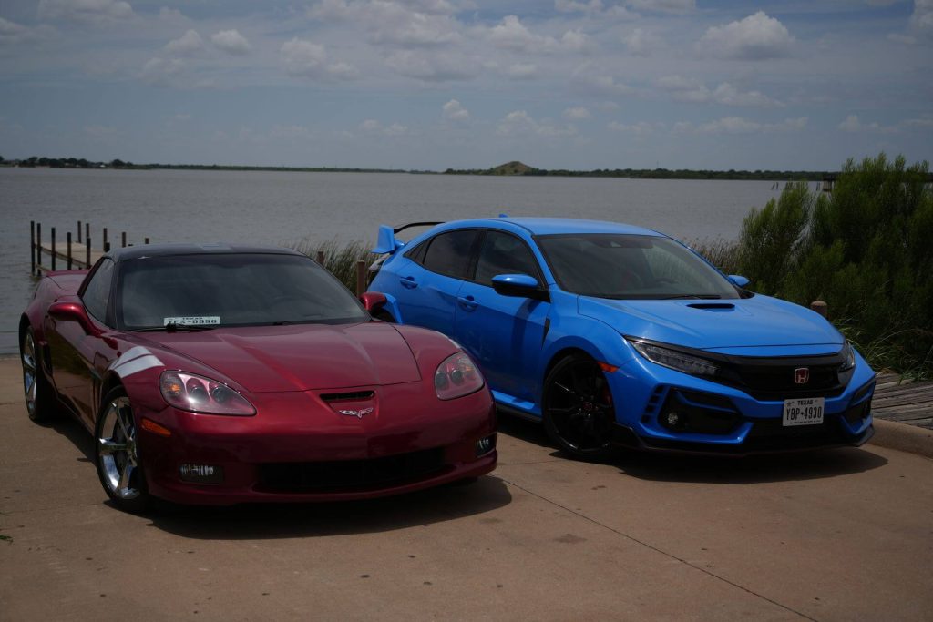two sports cars parked lakeside